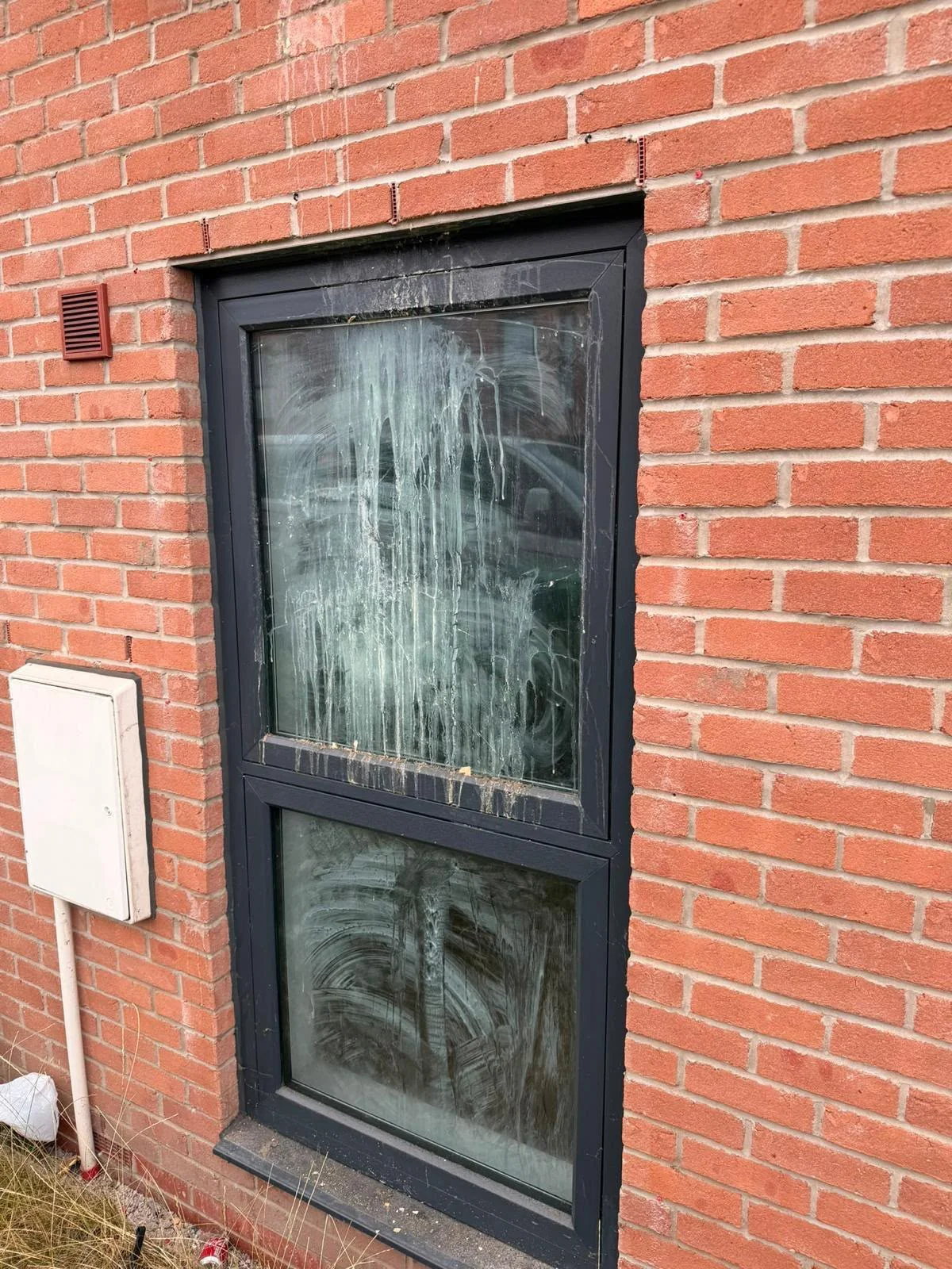 Brick wall and window frame stained with white mortar slurry