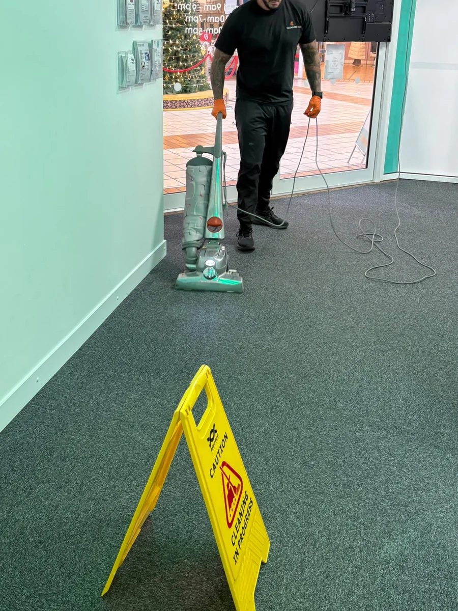 Technician pre-vacuuming commercial salon carpets