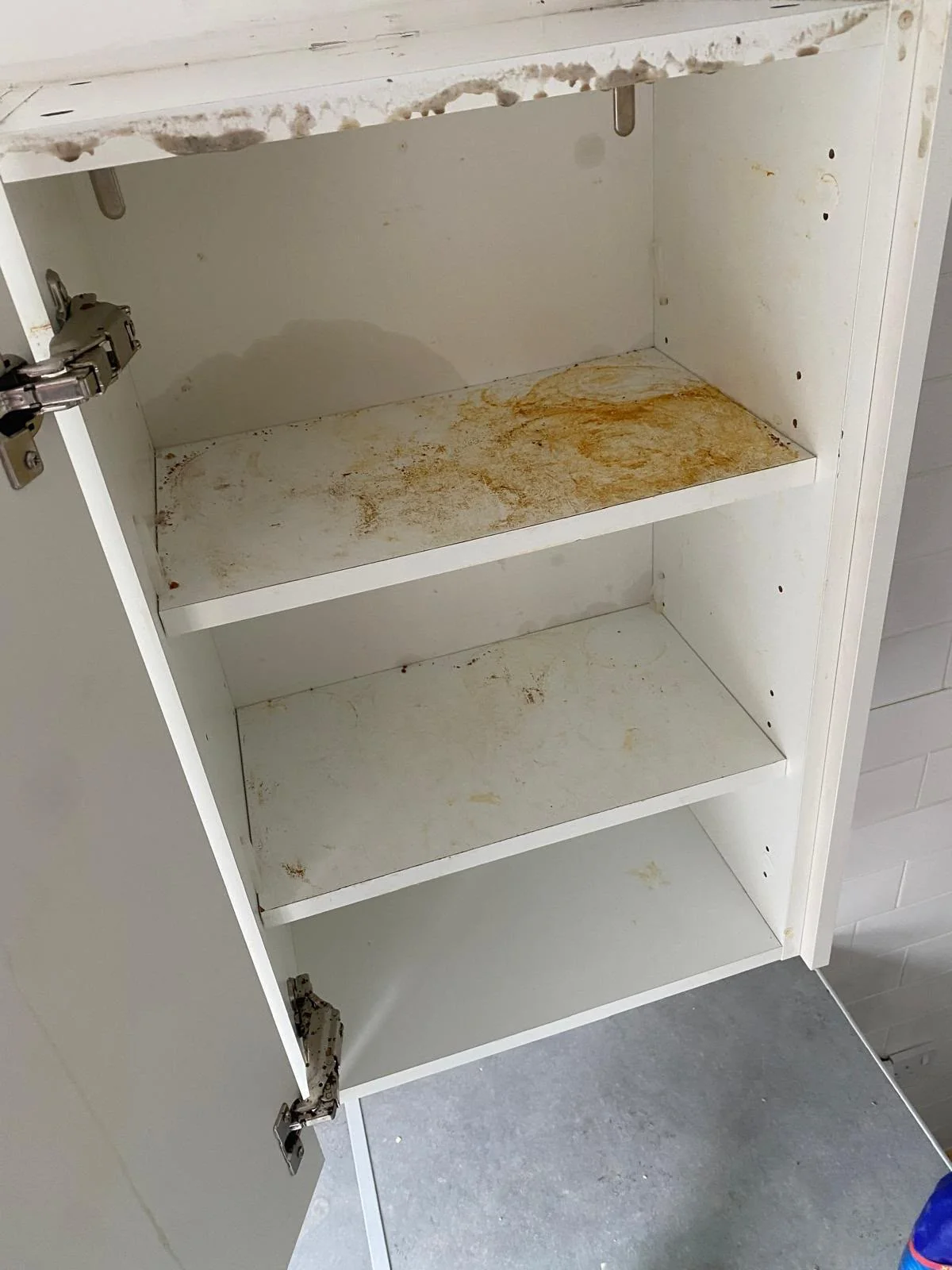Wall-mounted kitchen cupboard covered in cooking grease