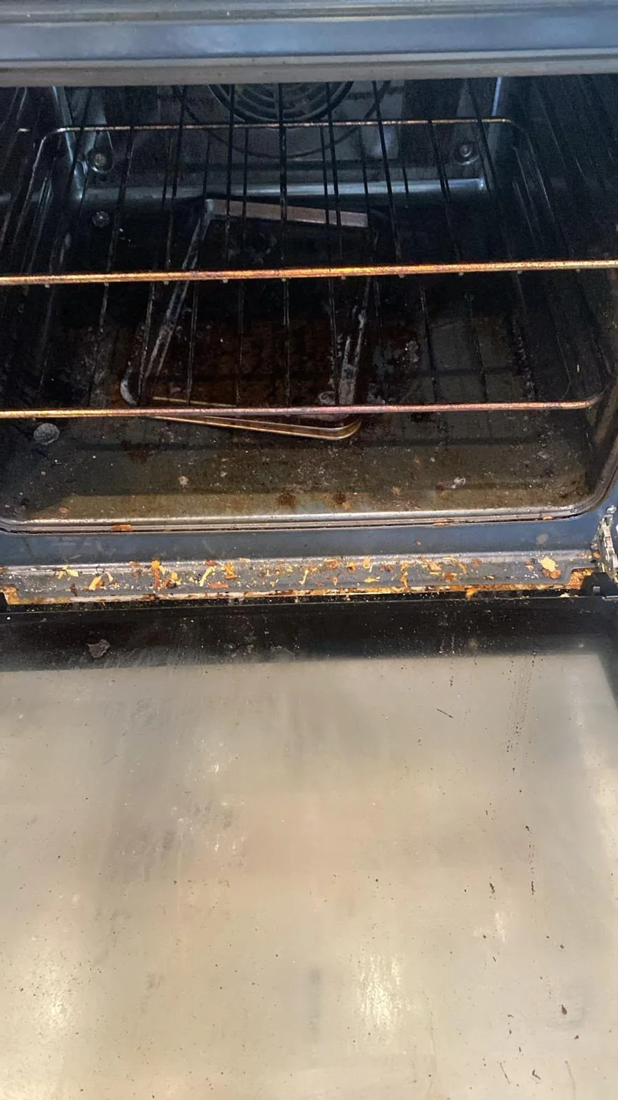Oven interior covered in burnt grease before cleaning