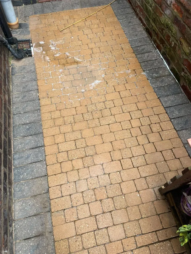 Side passage block paving being pressure washed