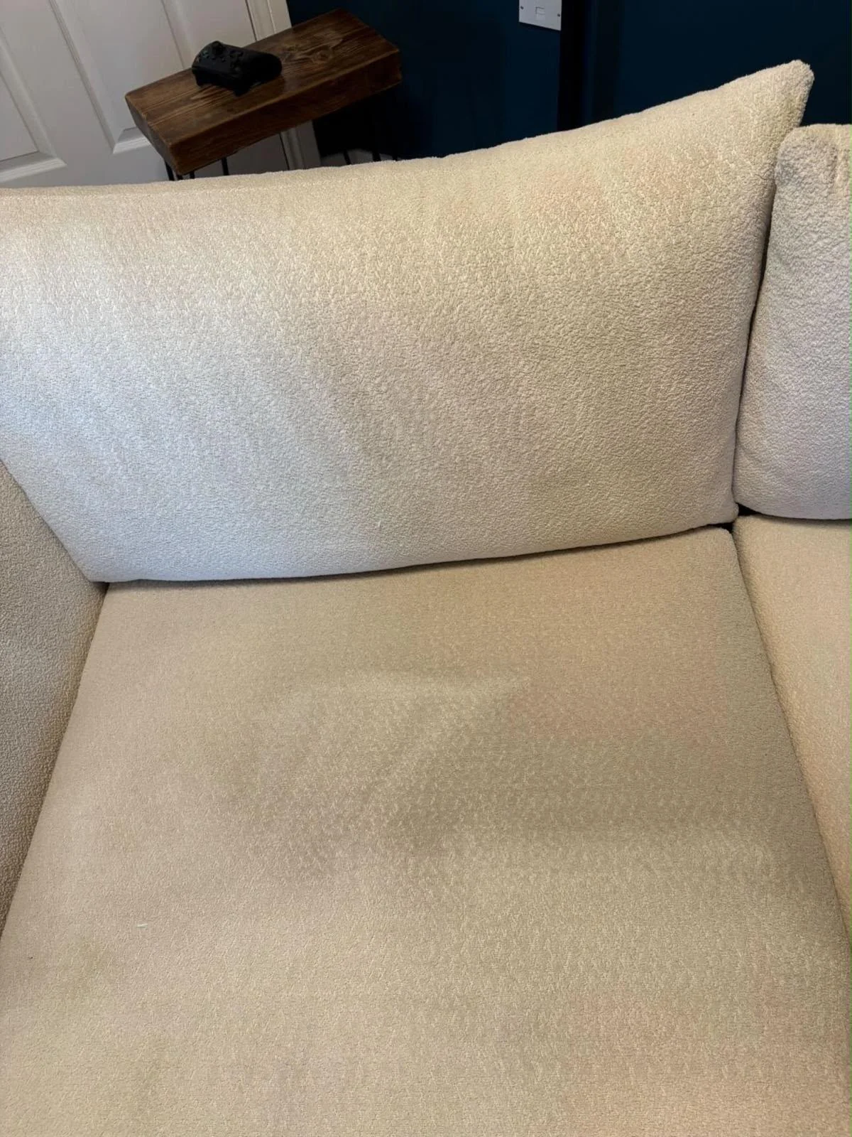 Cream fabric sofa seat cushion with dirt and stains before cleaning